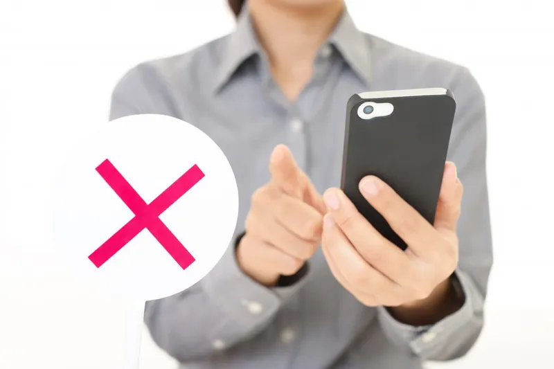 スマホを持って指を指す女性